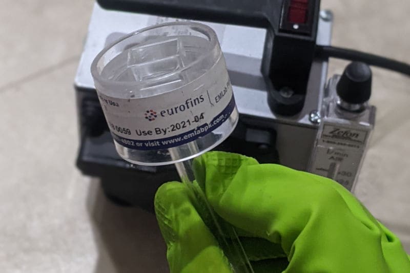 air quality specialist holding a cartridge with air sample to be sent to mold testing lab